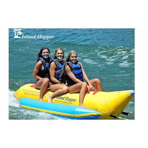 3 girls riding a yellow Island Hopper 3 Person Banana Boat Tube with light blue inflatable foot rests. On a white background. 