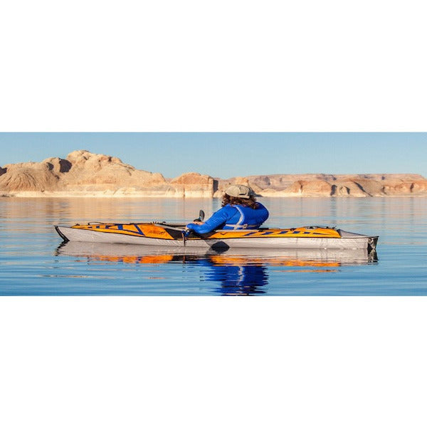 Advanced Elements 1 Person AdvancedFrame Sport Inflatable Kayak display view.  Orange and blue inflatable kayak design with grey interior, nose, and side walls. Image on a white background. 