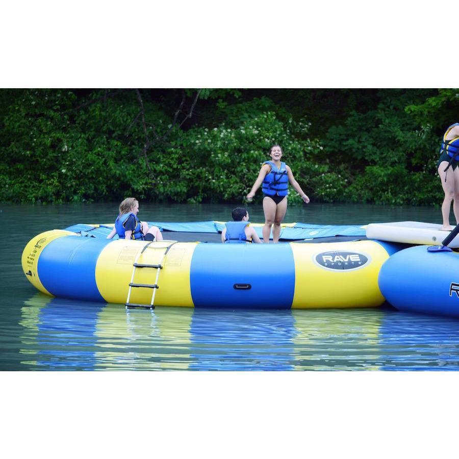 Adults and kids playing on the yellow and blue Rave Aqua Jump Eclipse 200 Water Trampoline out on the lake.  Ladder is visible on the side.