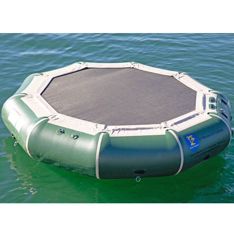 Hunter Green Island Hopper 13' Bounce N Splash Inflatable Water Bouncer in the lake with 1 kid standing on the black bouncer surface. 