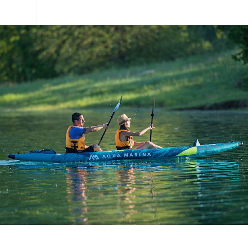 Two people kayaking on a calm lake with Aqua Marina steam inflatable kayak