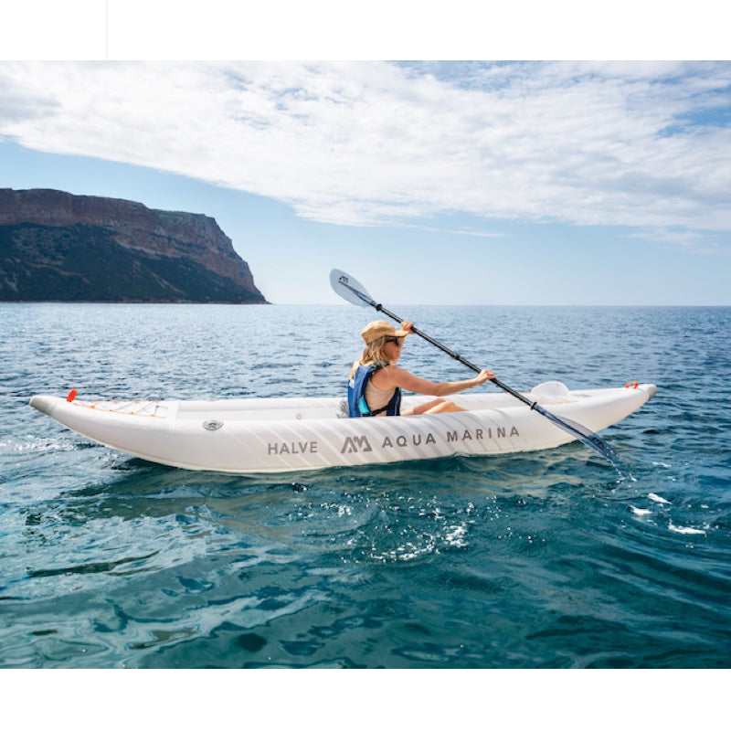 Person kayaking in the ocean with a scenic background
