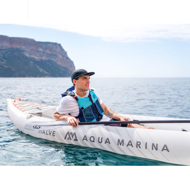 Person kayaking in a white kayak with Aqua Marina branding on a body of water.