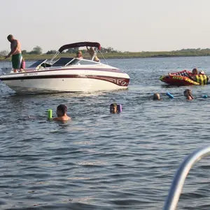 Boating on a lake with accessories to play with. Boating tubes and sea scooters in use.