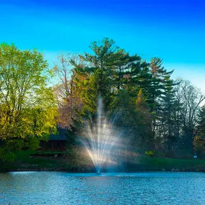 A beautiful floating fountain display sprays up from a pond.