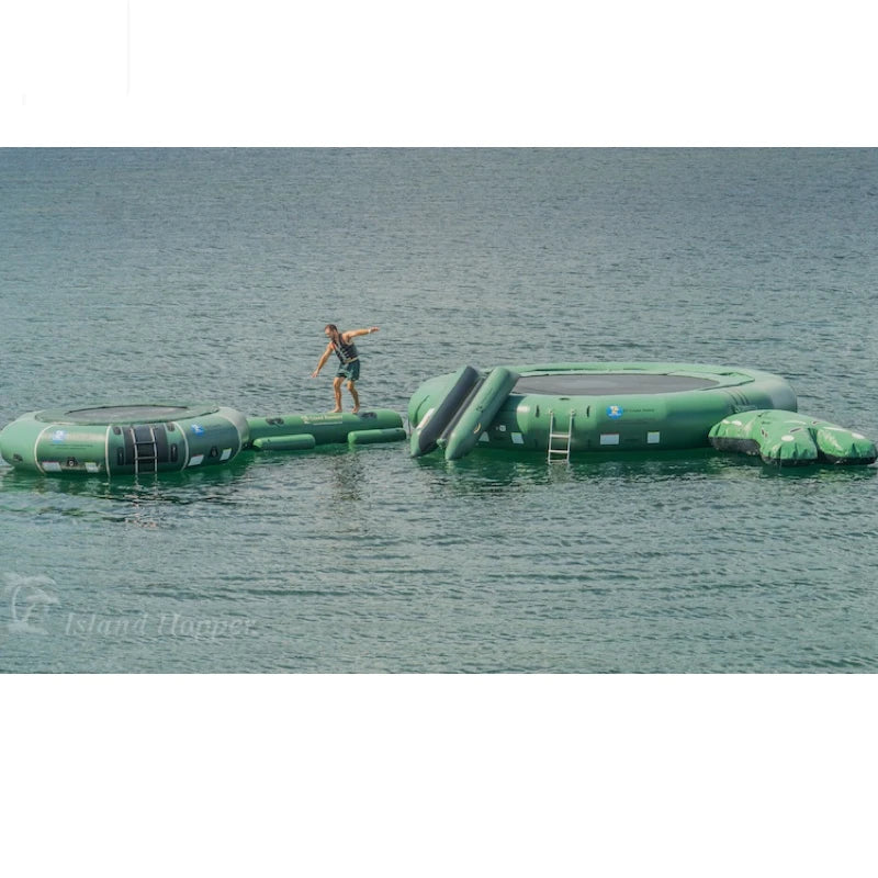 Inflatable water trampolines connected by an inflatable beam. All are floating on water with a person running between them.