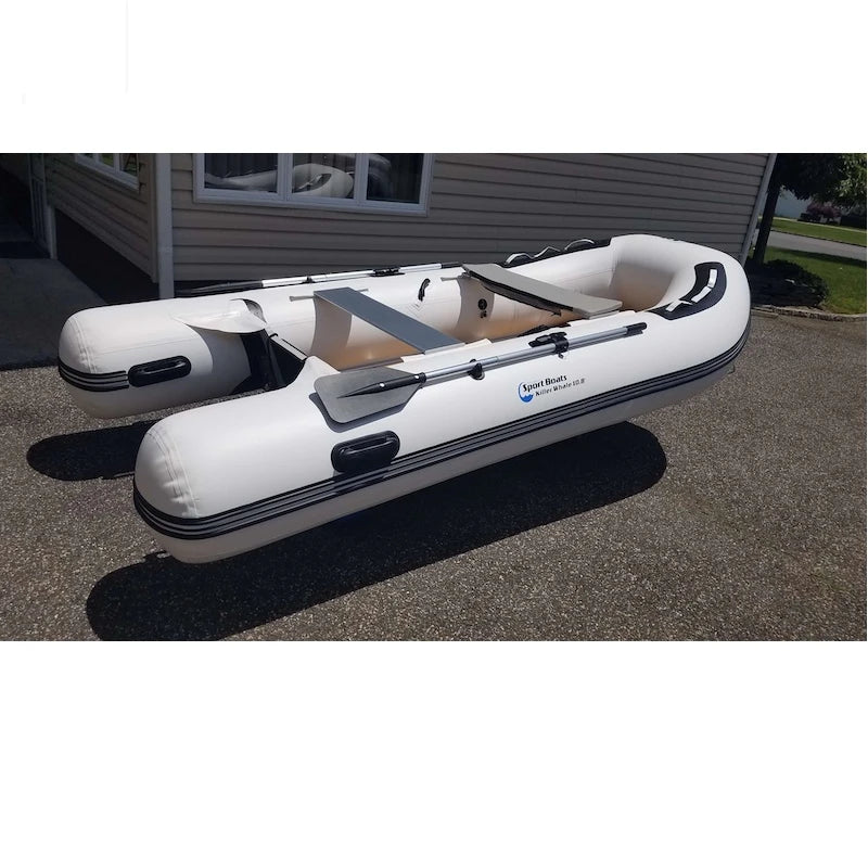 Inflatable boat on dinghy wheels in a driveway with a house in the background