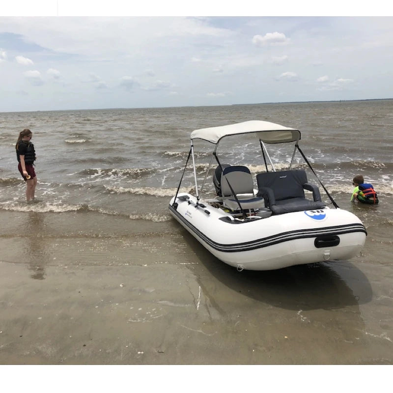 Inflatable boat on a sandy beach with two people nearby
