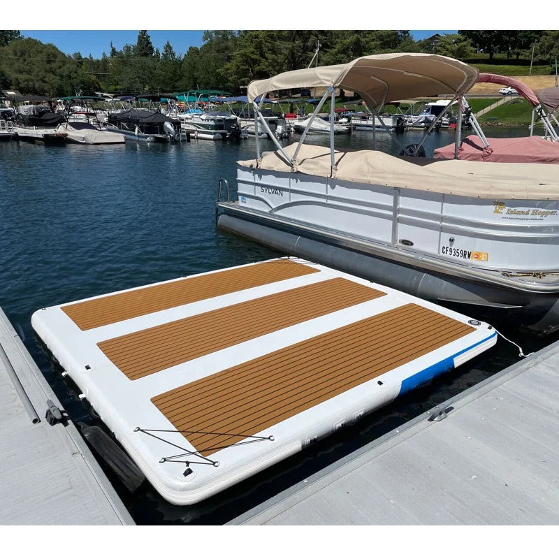 Inflatable floating dock with brown and white design on a docked boat in a marina.