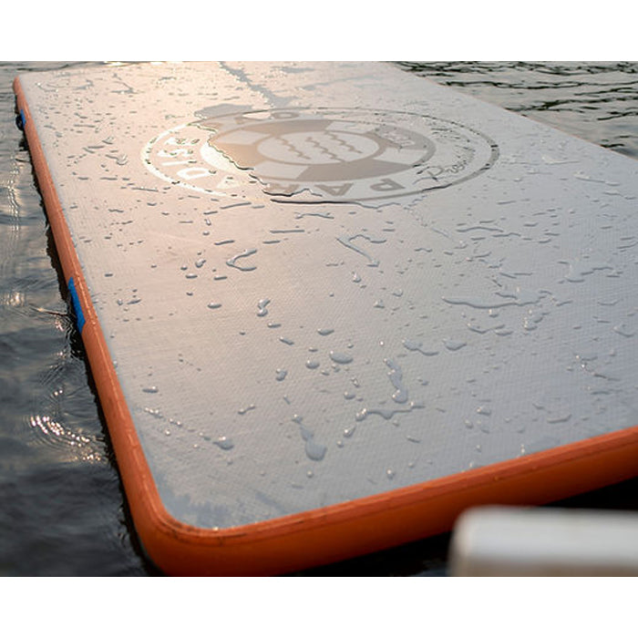 Paradise Pad 6&#39;x10&#39; Inflatable Water Mat on the water with splashes of water on the mat.