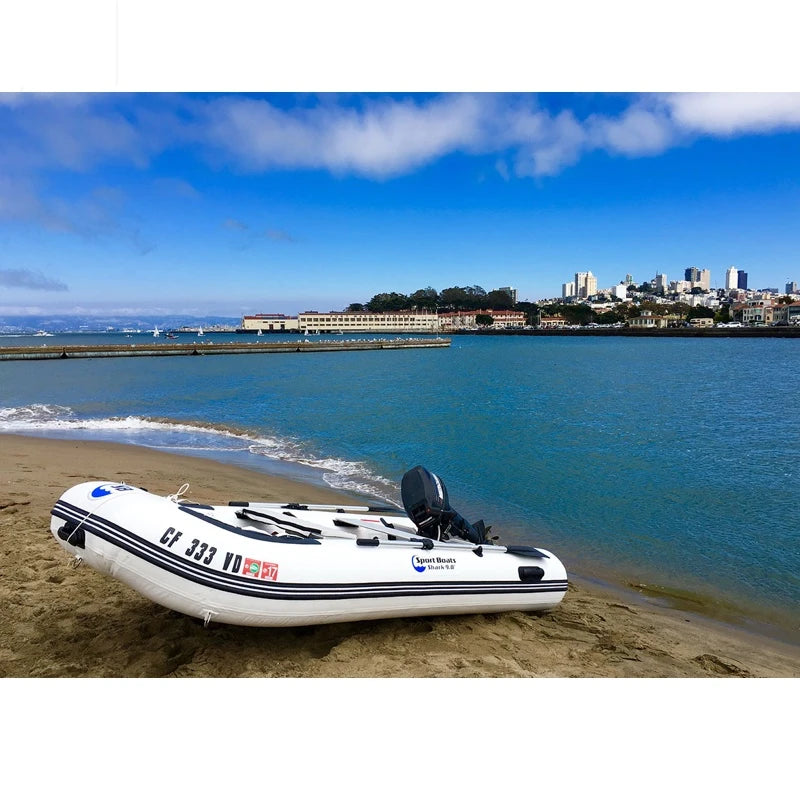Inflatable boat on a sandy beach with a cityscape in the background