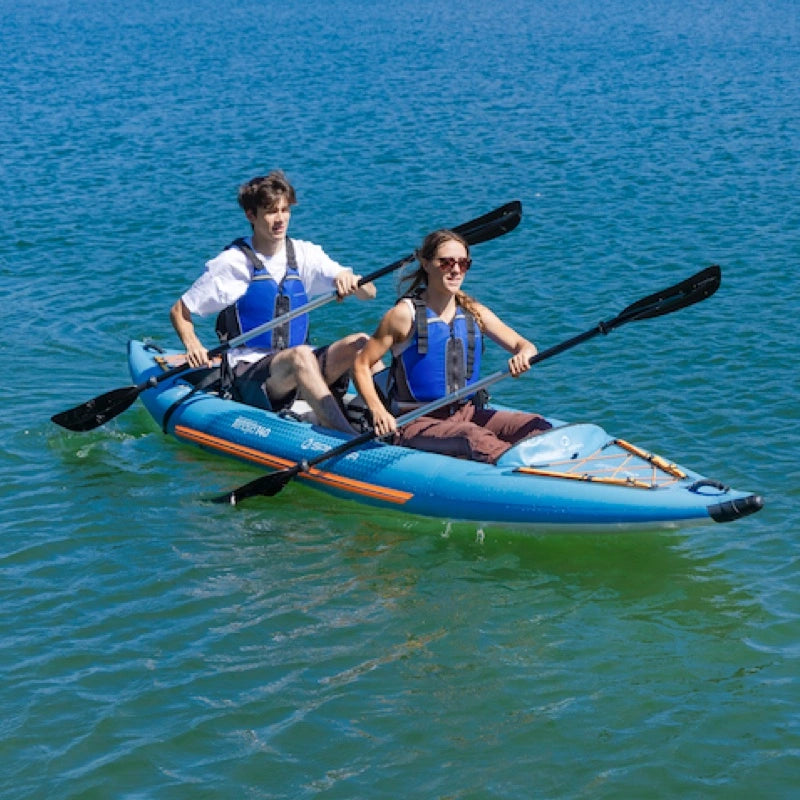 Two people in a blue inflatable kayak on calm water