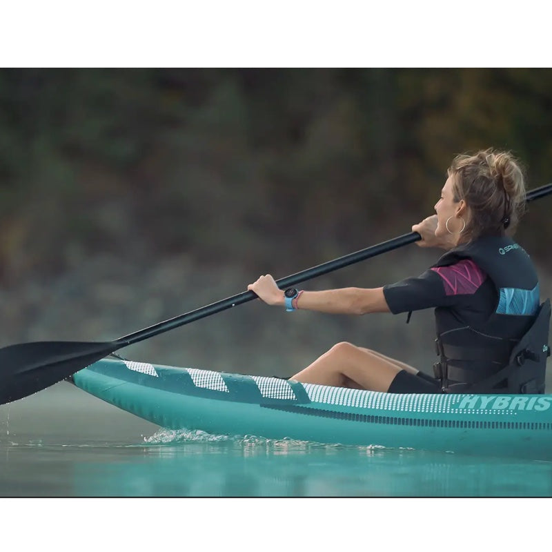 Person kayaking on a body of water wearing a life jacket.