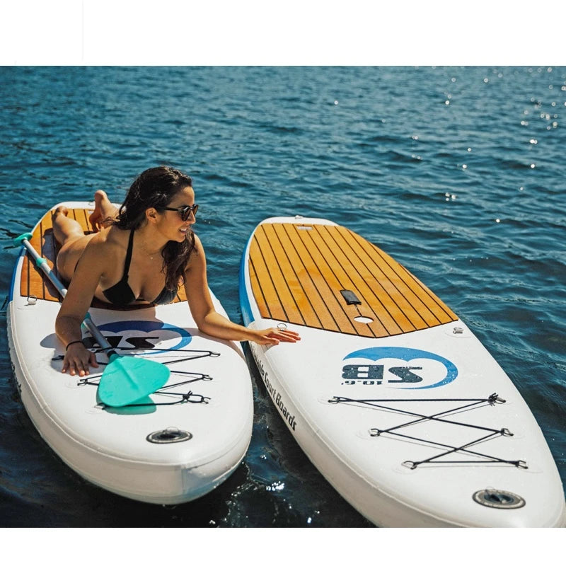 Woman on an inflatable paddleboard with another board next to her on calm water