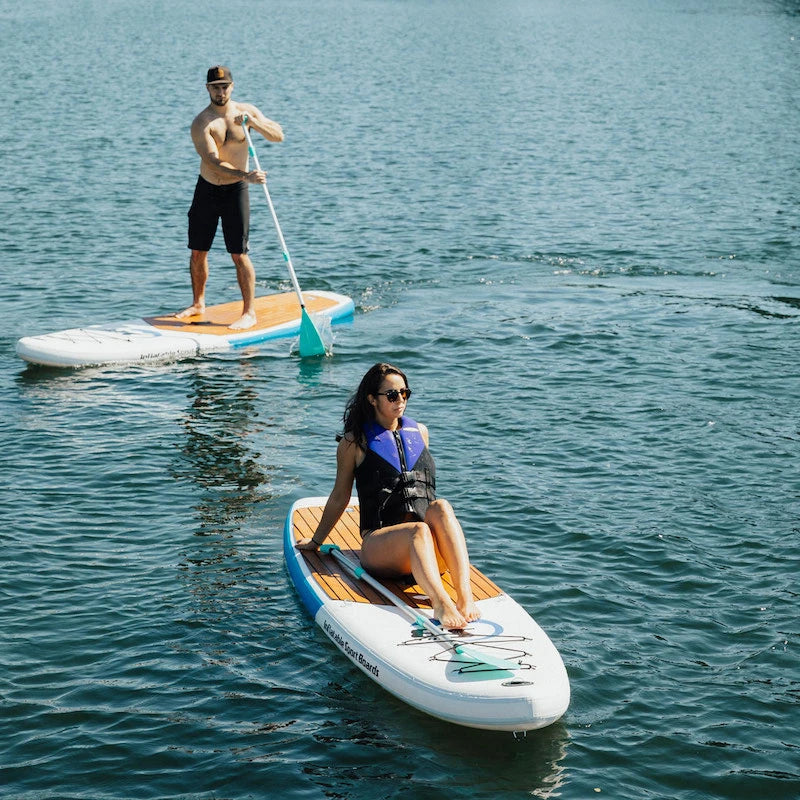 Two people paddleboarding on a calm body of water.