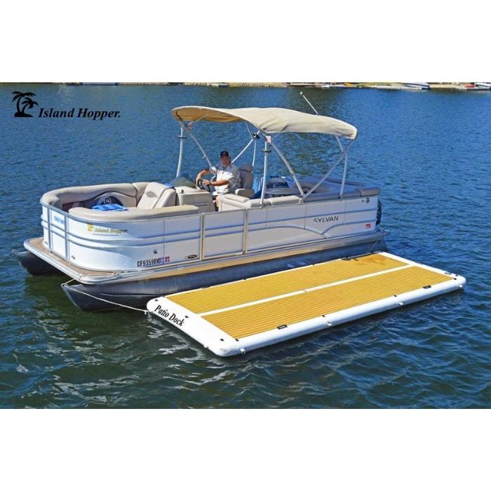 The Island Hopper Patio Dock Floating Swim Platform is shown attached to a pontoon with nobody on it so that you can fully see the EVA foam non-slip surface which is tan in color as well as the white inflatable dock border.