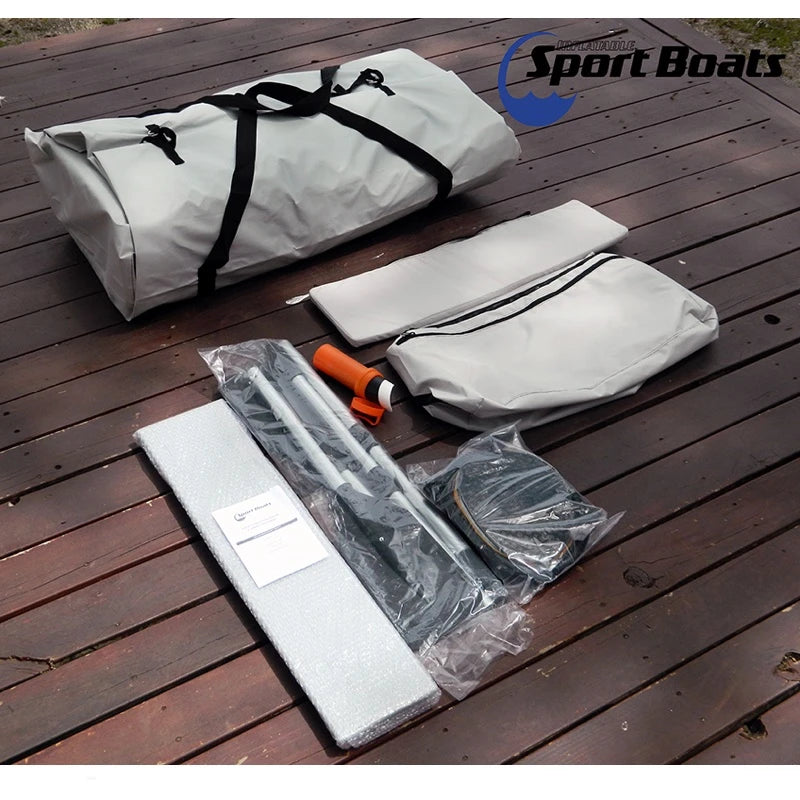 White Marlin inflatable boat, including items. Product packaging on a wooden surface with tools and parts.