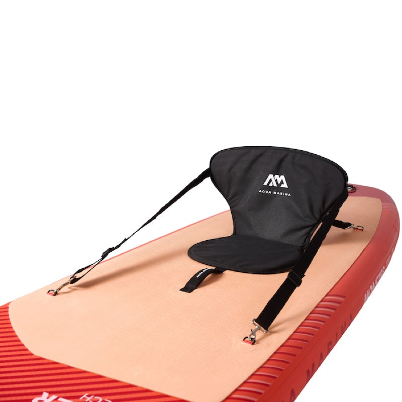 Black SUP seat with straps on a red and beige inflatable mat, featuring a logo.