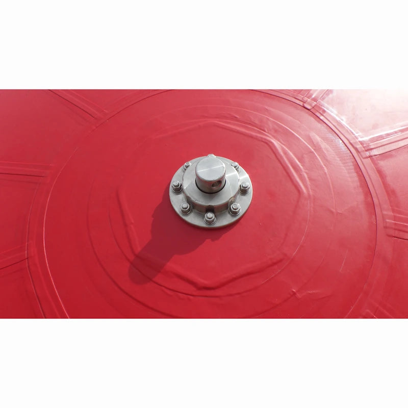 Close-up of the spinning contraption with a metallic bolt on a red surface  on a white background