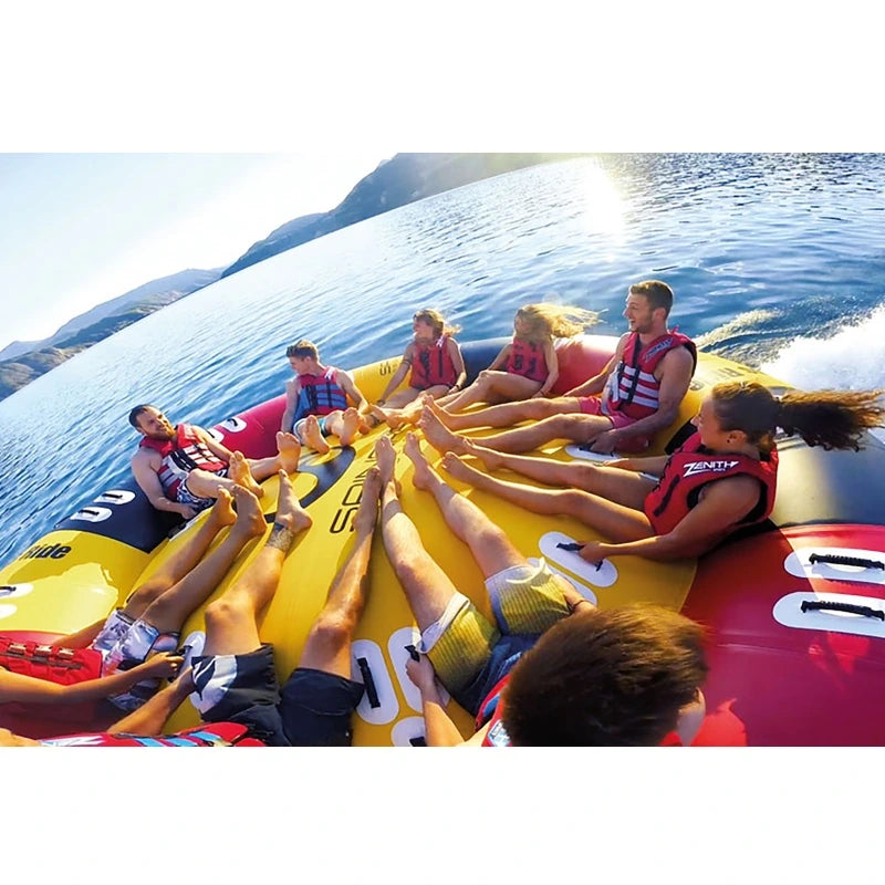 Group of people on a large inflatable tube in the water with mountains in the background