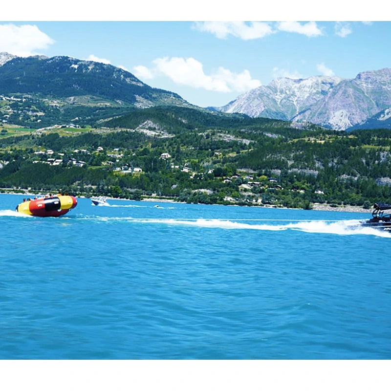 Endless Ride 8–12 tube pulled by a boat on a blue lake with mountains in the background