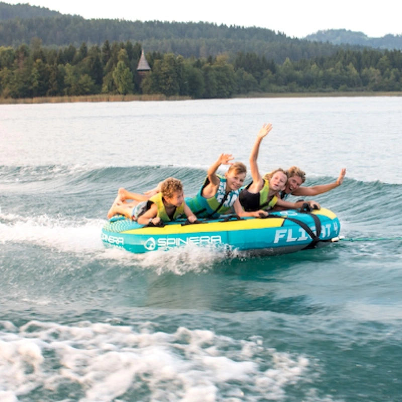 Children on a inflatable tube in a lake with trees in the background