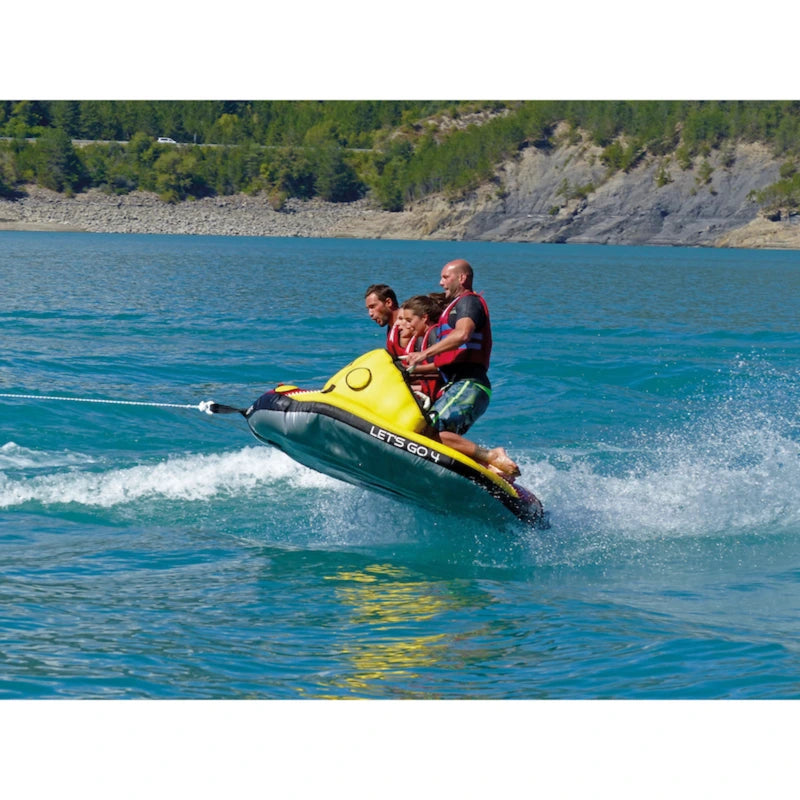 Two people on a towable tube in a body of water with a scenic background.