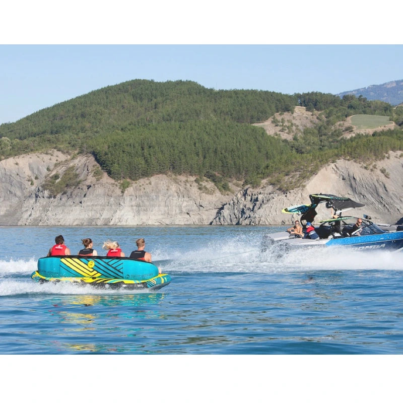 People on a water tube with a scenic background of mountains and water.
