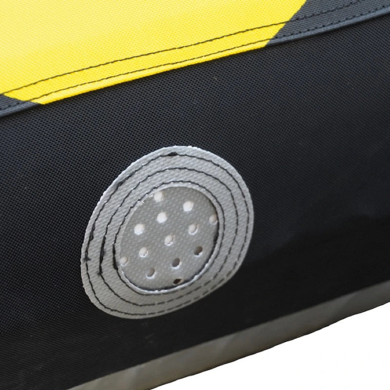 Close-up of a black and yellow boating tube vent with a gray circular patch featuring holes.
