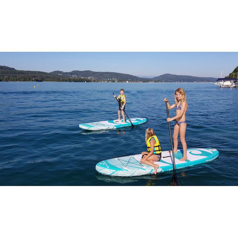 Three people paddleboarding on a calm lake with mountains in the background