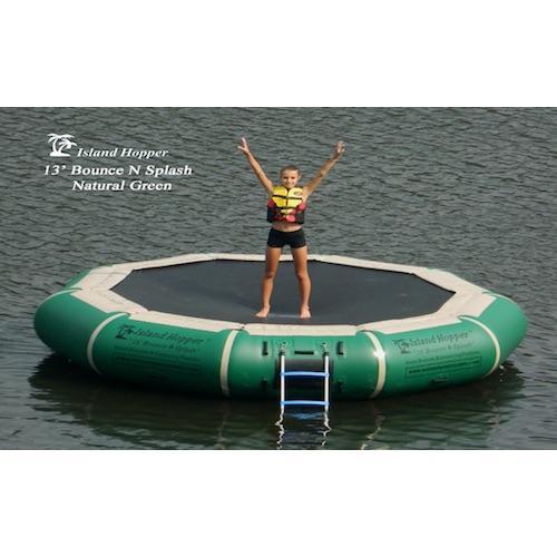 Hunter Green Island Hopper 13' Bounce N Splash Inflatable Water Bouncer in the lake with 1 kid standing on the black bouncer surface. 