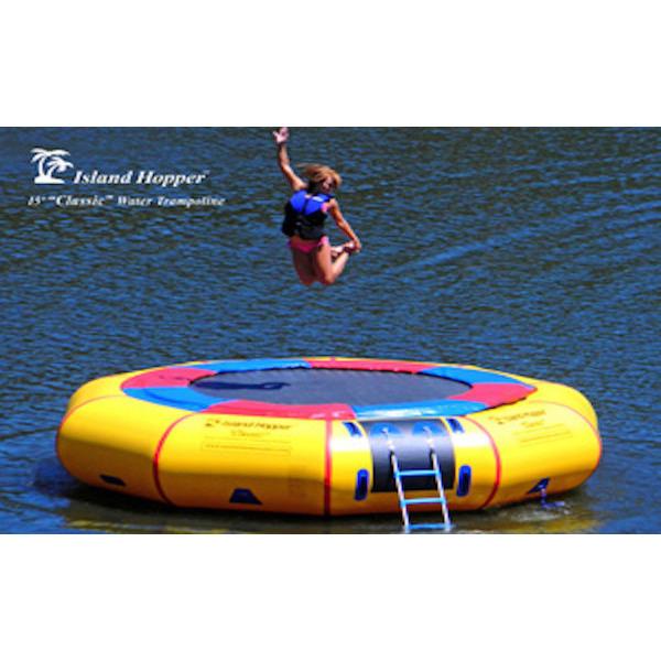 Yellow Island Hopper 15&#39; Classic Water Trampoline on the lake with girl jumping in the air