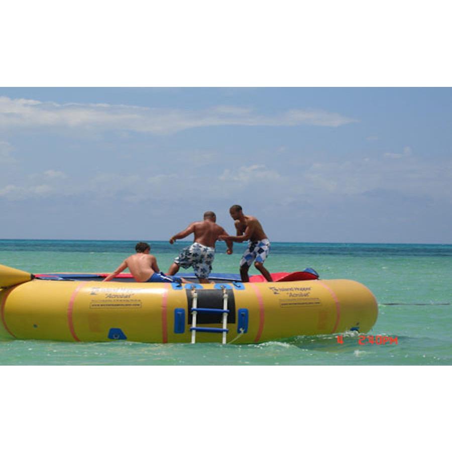 3 men playing on the yellow Island Hopper 20 Acrobat Water Trampoline in the ocean. 