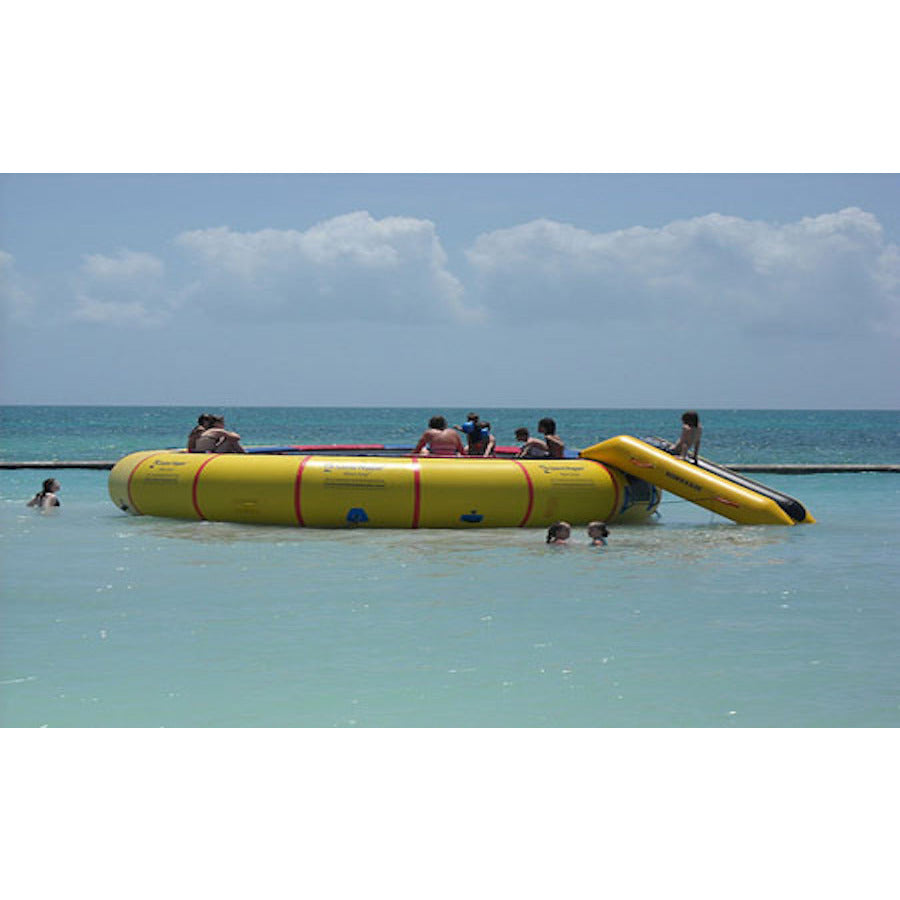 Yellow Island Hopper 25ft Giant Jump Water Trampoline on the ocean with several people on it.  Bounce N Slide attachment also in use. 