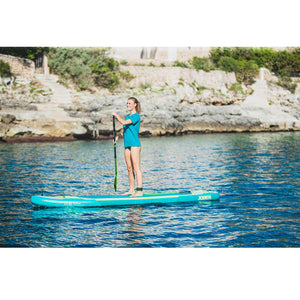 Loa 11.6 Inflatable Paddle Board in the middle of the ocean with an adult female standing up, paddling on it.
