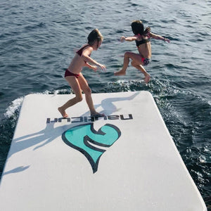 NautiPad Inflatable Swim Mat on the water with girls jumping from it to the water.
