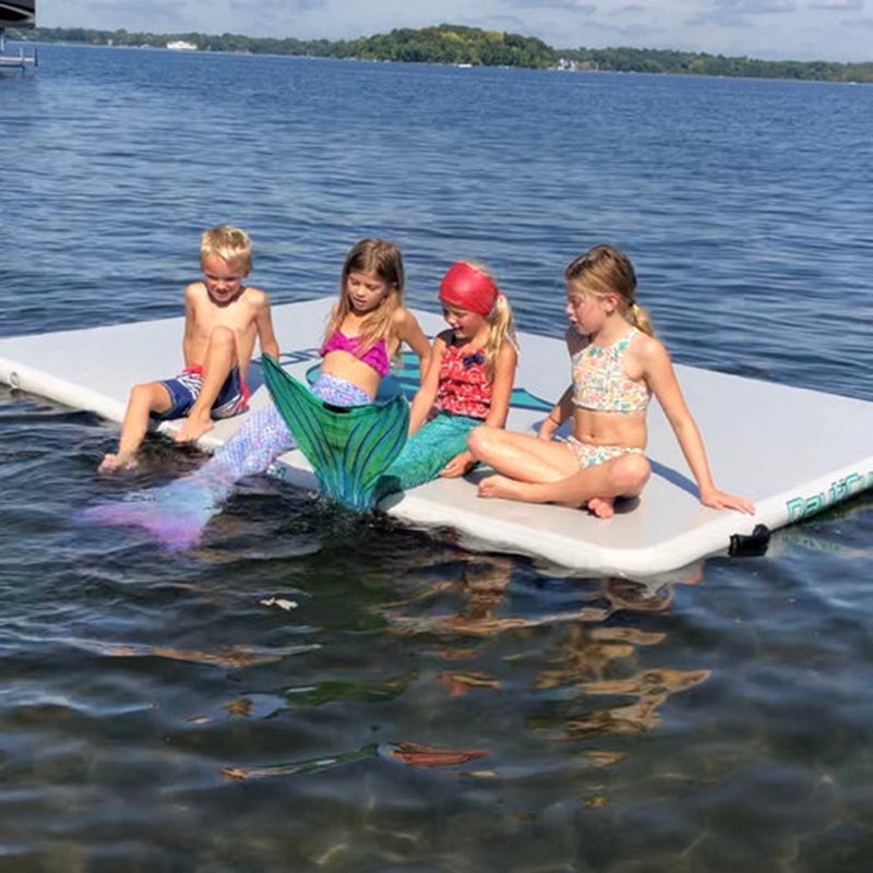 NautiPad Inflatable Swim Mat on the water with 4 kids sitting on it.