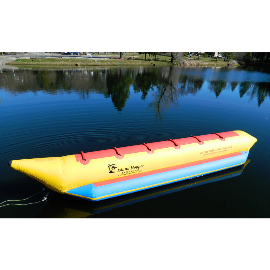 Side view of an Island Hopper 6 Man Banana Boat Tube sitting on the water.  Yellow inner tube with light blue inflatable foot rest and red seating. 