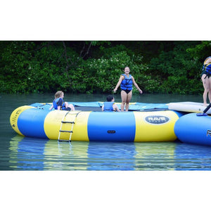 Adults and kids playing on the yellow and blue Rave Aqua Jump Eclipse 200 Water Trampoline out on the lake.  Ladder is visible on the side. 