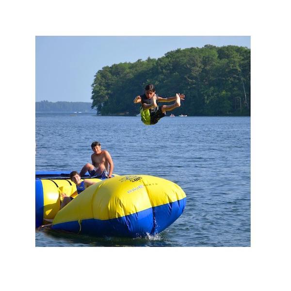 A young buy flys off the Aqua Launch after his friend jumps and lands on the other side of the launch.  Great fun, flying thru the air into the lake.