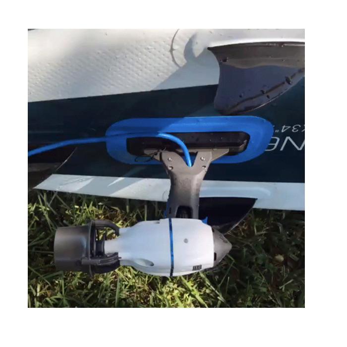 Bixpy Outboard Kayak Motor being used with the Bixpy Adapter for Inflatables.  The Bixpy Kayak Jet Motor is attached to the bottom of inflatable kayak.  The grey body of the Bixpy Jet is connected to the inflatable kayak with a royal blue sealed attachment. 