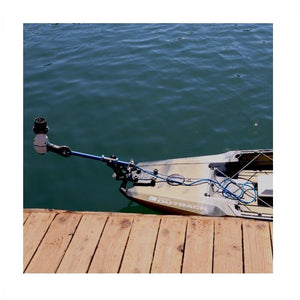 Bixpy Universal Power Pole Kayak Adapter  is shown hinged out of the water while docked.  Only the back portion of the kayak is visible.