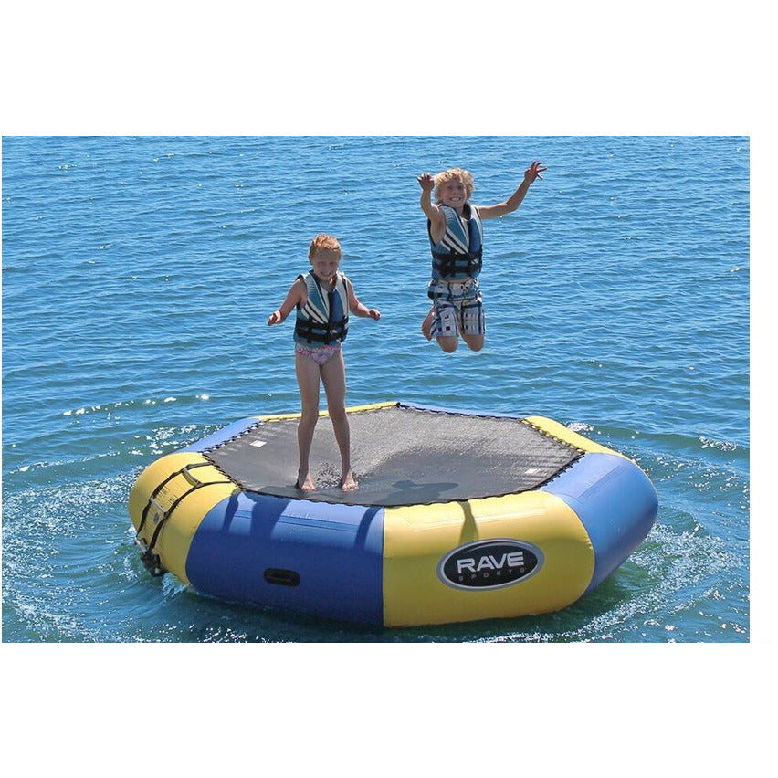 2 kids bouncing on a blue and yellow Rave Bongo 10 Water Bouncer on the lake.
