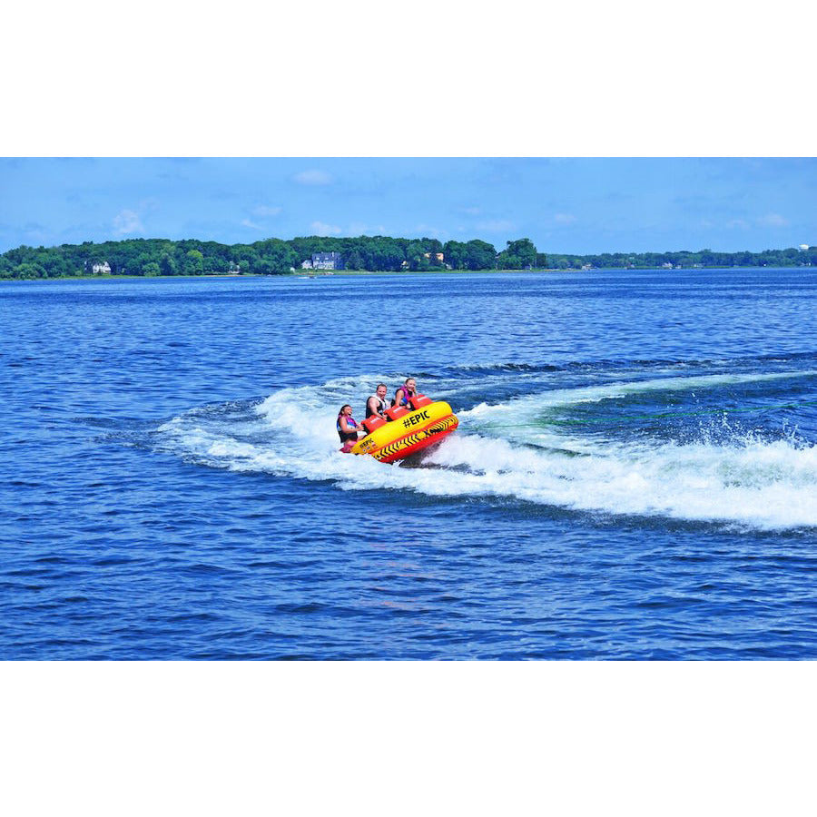 Yellow and Red RAVE #Epic 3 Person Towable Boat Tube pulled behind a boat on the lake. 