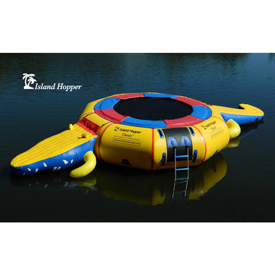 Top/Side view of Island Hopper 15' Gator Monster Water Trampoline Water Park sitting unoccupied on a calm lake.  Yellow inner tube with blue and red trim and black water trampoline surface. 