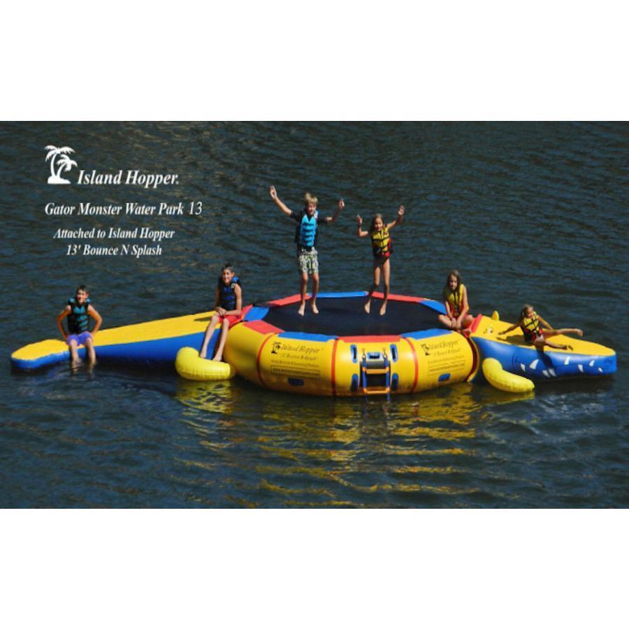 Kids playing on the Island Hopper 13ft Gator Monster Water Bouncer Water Park in the lake.  Side view.