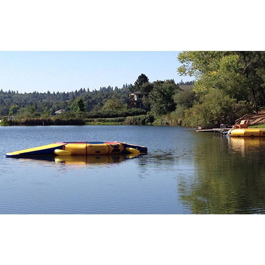 Side view of the Island Hopper 13ft Gator Monster Water Bouncer Water Park sitting in a calm lake.  Yellow Monster Water Park not occupied.