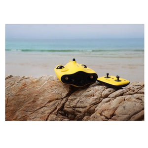 A Chasing Gladius Mini Underwater Drone with the Remote Control sit on a rock on the beach.  The underwater drone for sale is yellow as is the remote control with joysticks.