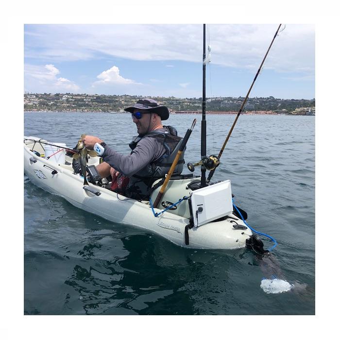 Out in a fishing kayak with the Bixpy Hobie Twist & Stow Kayak Rudder Adapter shown attached on the back of the white kayak in the water just below the surface with the Kayak Jet Motor attached.