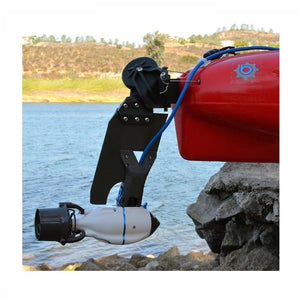 Bixpy Hobie Twist & Stow Kayak Rudder Adapter attached to the back of a red kayak near the water.